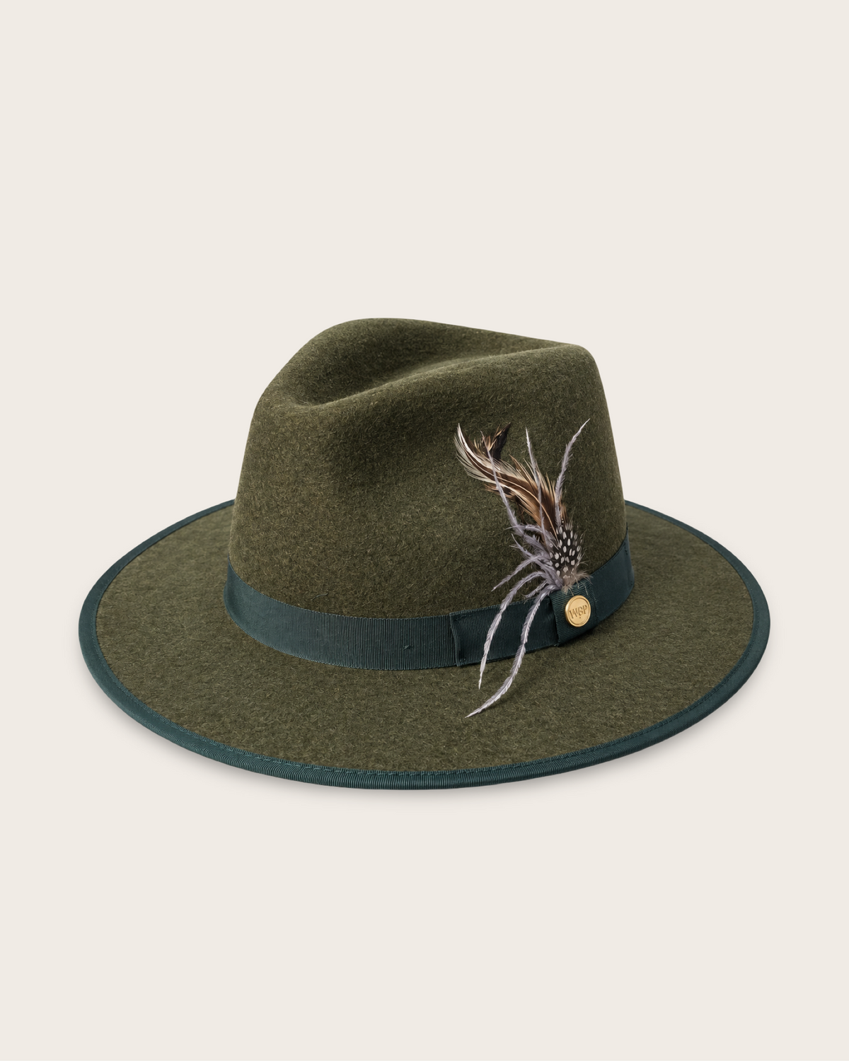 An olive green felt fedora hat with a dark green band and a decorative feather accent on the side, set against a solid off-white background.